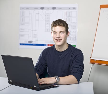 Un apprenti informaticien orientation développement d'applications pianote sur un ordinateur portable