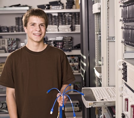 Un apprenti informaticien orientation technique des systèmes se tient dans la salle des serveurs