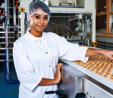 Une apprentie technologue en denrées alimentaires mesure des pièces en chocolat