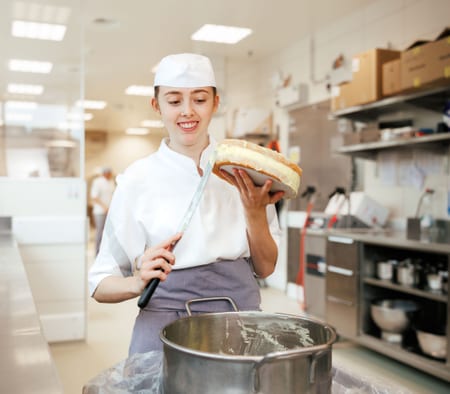 Frau bestreicht Kuchen