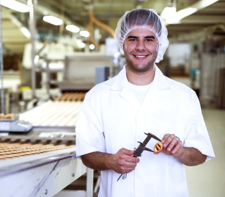 Un apprenti technologue en denrées alimentaires mesure la taille d’un biscuit
