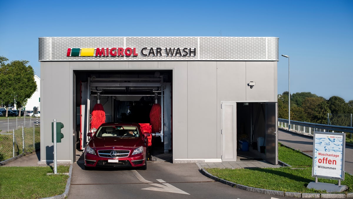 Ein rotes Auto fährt aus einer Autowaschanlage
