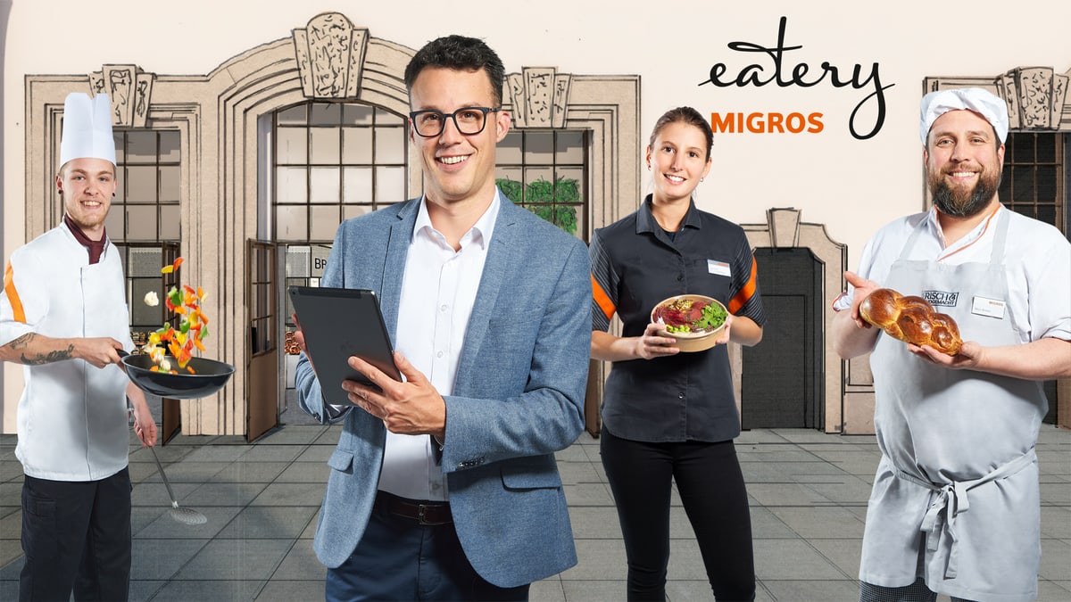 Personen vor Migros Eatery Kulisse