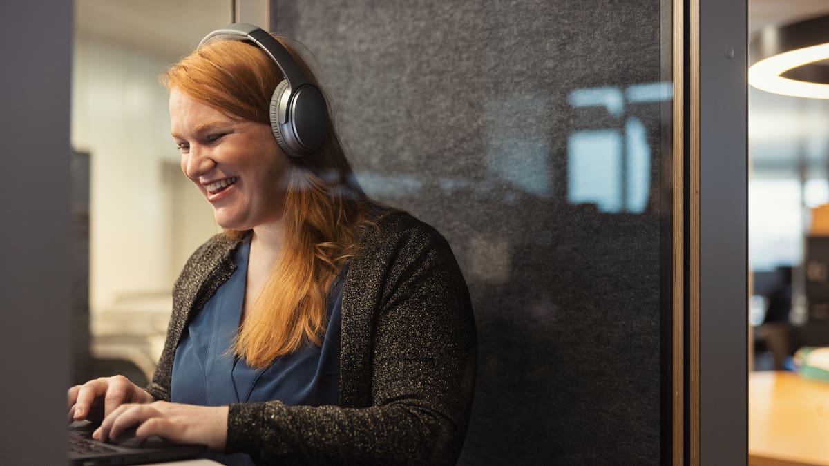 Frau in Telefonkabine mit Kopfhörer