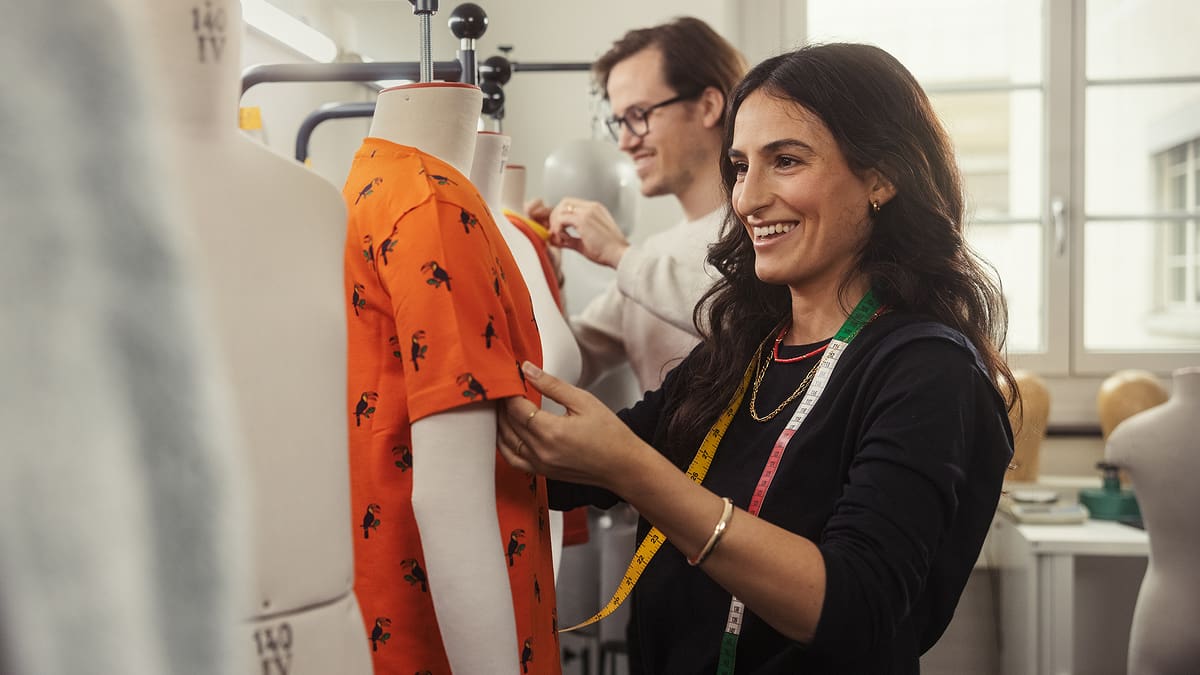 Zwei Personen beim Begutachten von T-Shirts