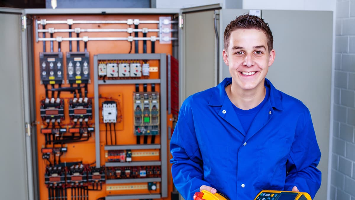 Lernender Elektroinstallateur hält Messgeräte in der Hand Lernender Elektroinstallateur hält Messgeräte in der Hand