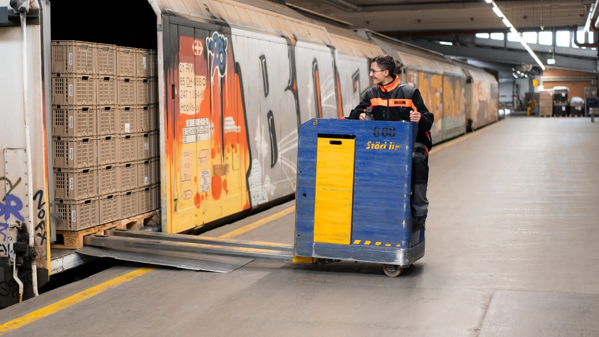 Junger Mann verlädt Objekte in Güterzug