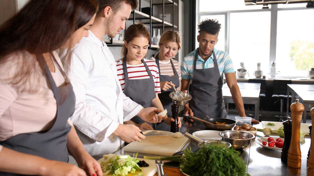 Vier Personen lernen, zu kochen