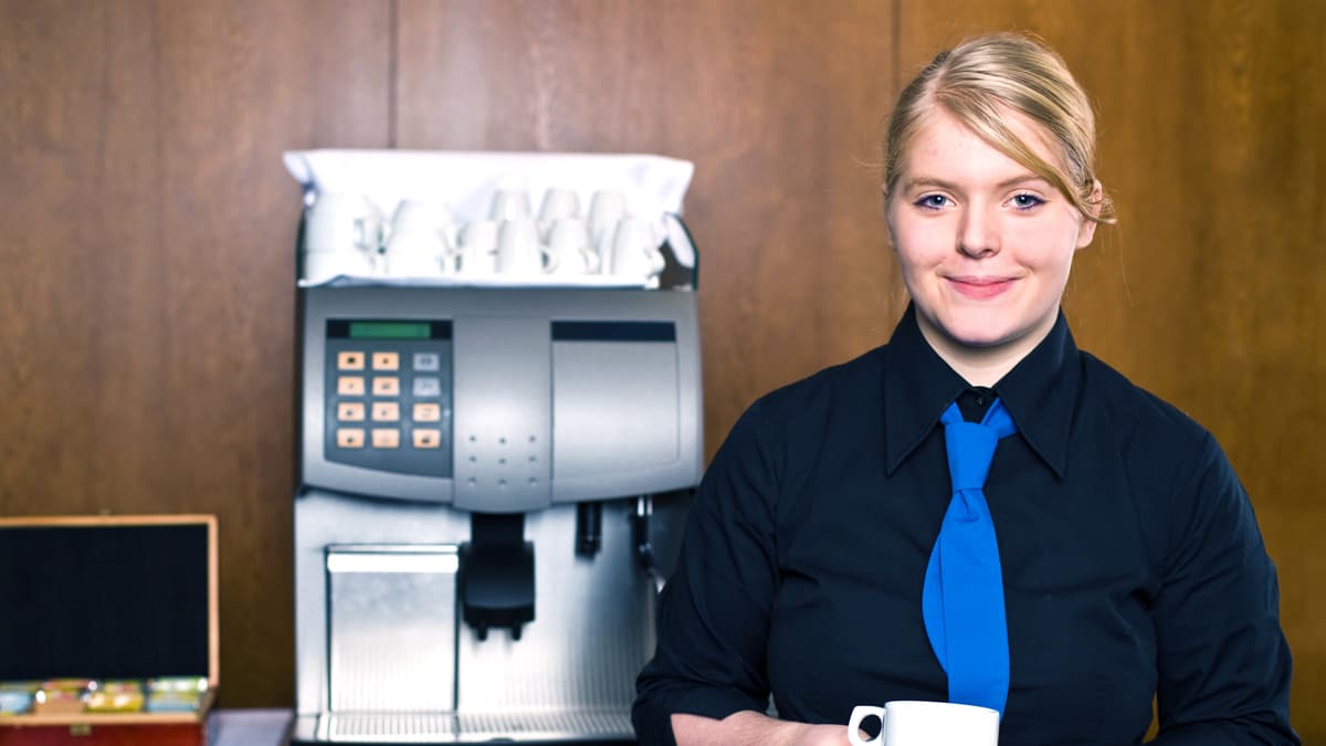 Lernende Restaurationsangestellte hält eine Kaffeetasse