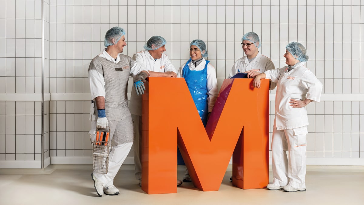 Gruppenfoto der Mitarbeiter mit dem orangen M