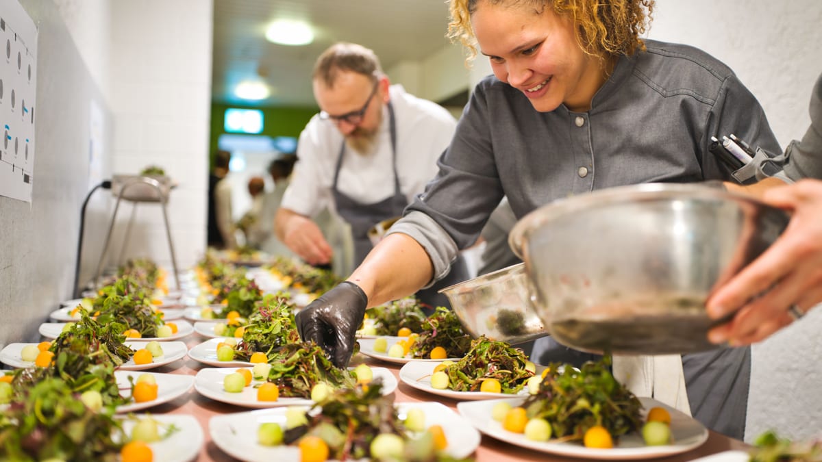 Mehrere Salate auf einem Tisch, Frau macht Feinschliff