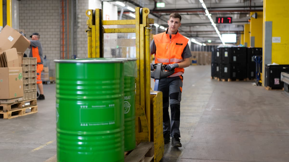 Mann manövriert Recycling-Fässer