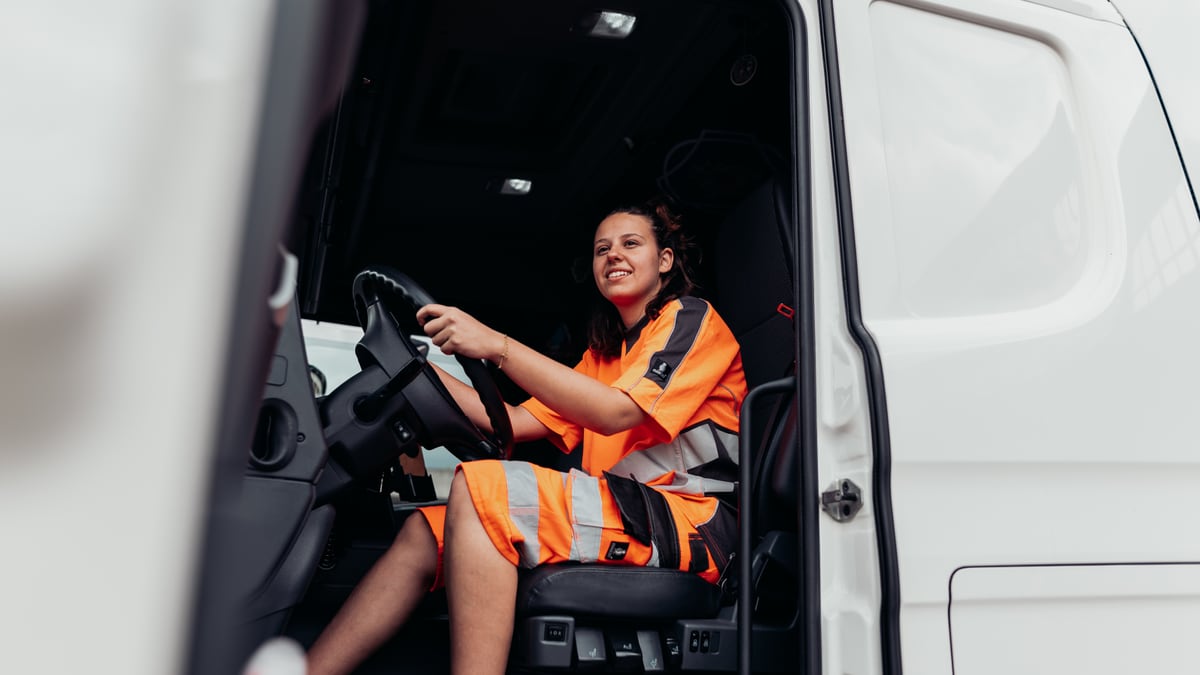 Junge Frau sitzt an Steuer von LKW