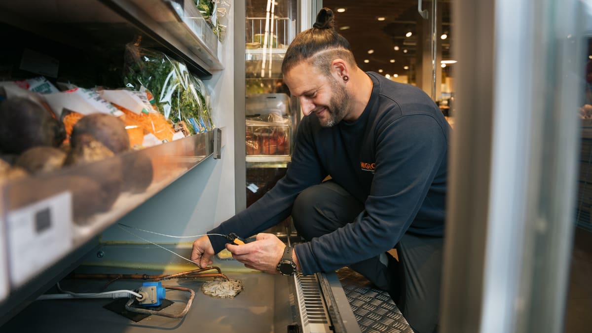 Mitarbeiter ist eine Kühltheke am reparieren