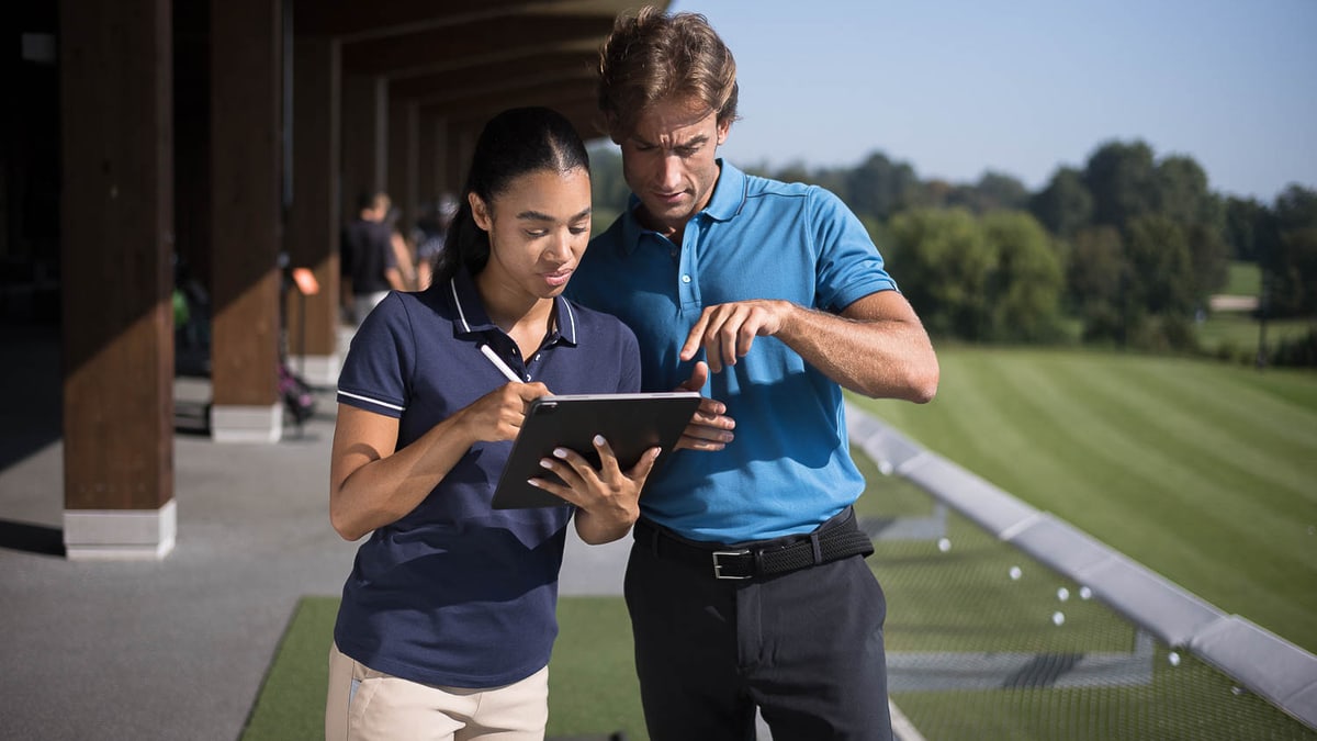 Zwei Personen am Golfplatz mit Klemmbrett