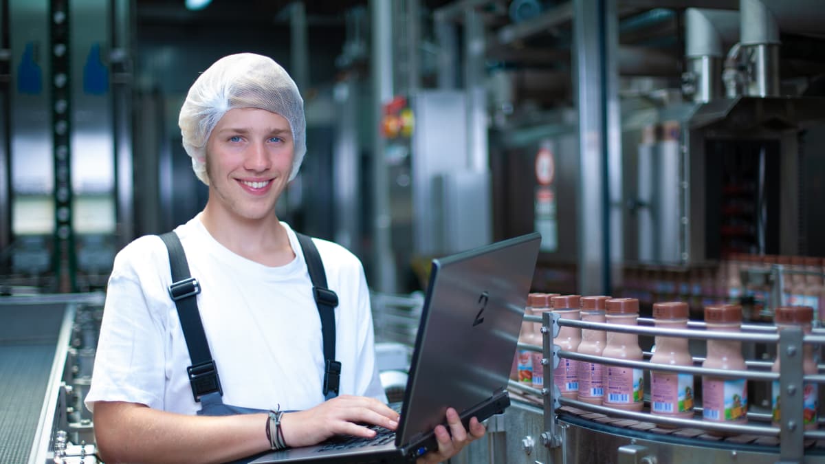 Lernender Automatiker steht mit Laptop neben dem Laufband