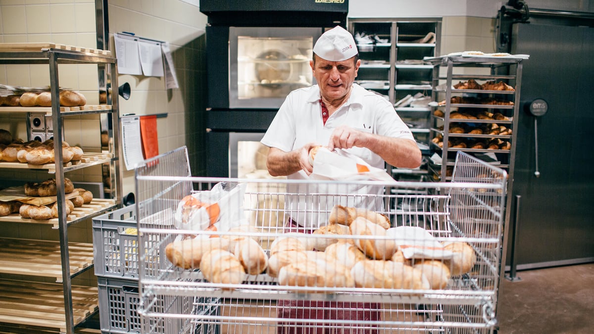 Collaborateur de la boulangerie maison JOWA emballant du pain