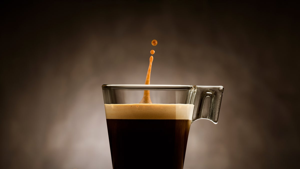 Kaffee im Glas mit Spritzer