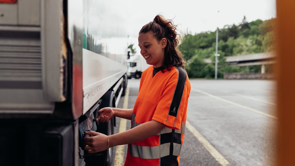 Junge Frau stellt etwas an LKW ein