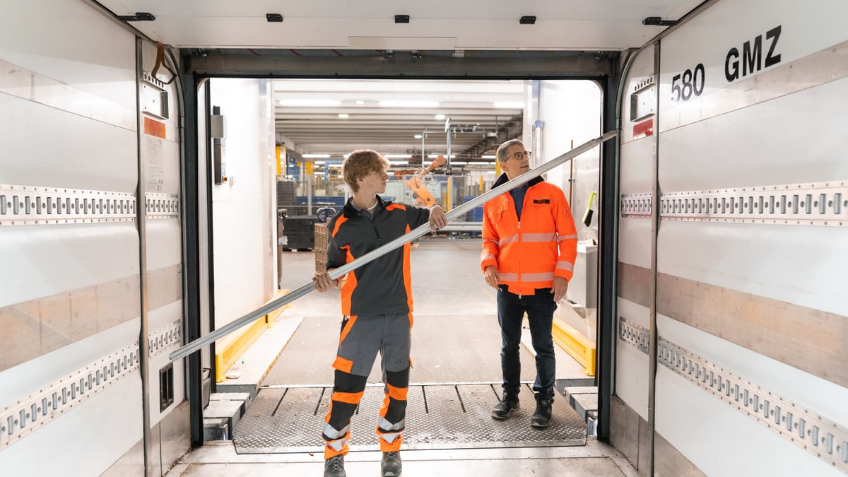 Mann hält Stange und richtet Ladefläche in LKW ein