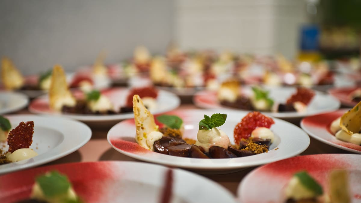 Blick auf Tisch voller Desserts aus Vanilleglace, Minze und Beeren