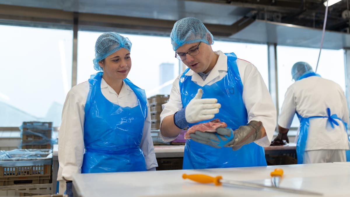 Ein Mitarbeiter erklärt wie Fleisch schneiden