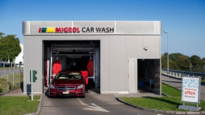 Ein rotes Auto fährt aus einer Autowaschanlage