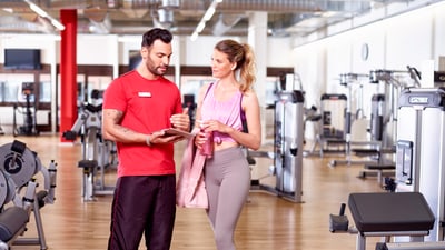 Fitnessinstruktor beratet Kundin