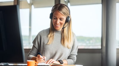 Frau mit Headset an Arbeitsplatz