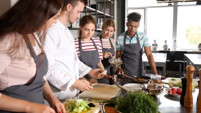 Vier Personen lernen, zu kochen
