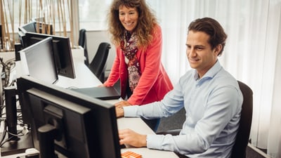 Zwei Personen im Gespräch am Arbeitsplatz