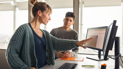 Zwei Personen im Gespräch am Arbeitsplatz