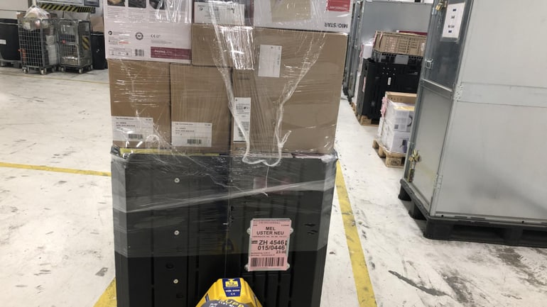 Una persona trascina un trolley con del materiale