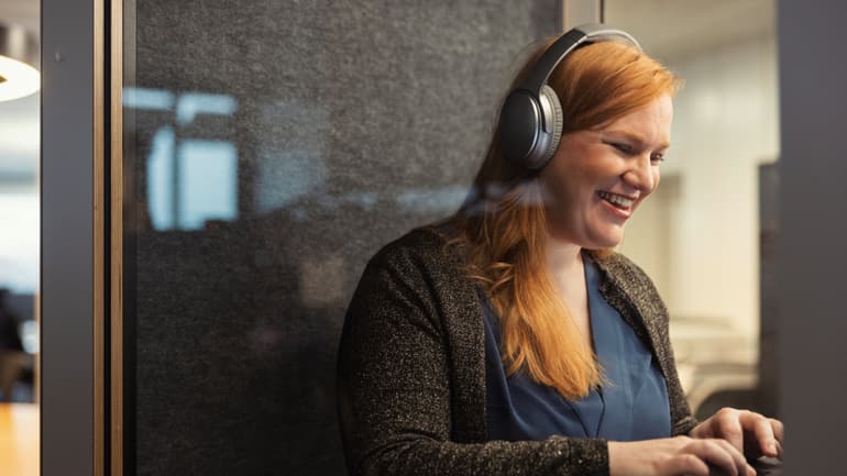 Frau mit Headphones am Laptop