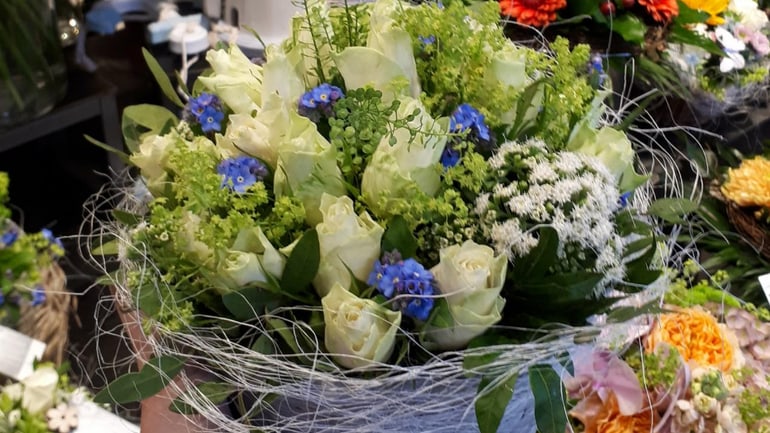 Hand hält Blumenstrauss