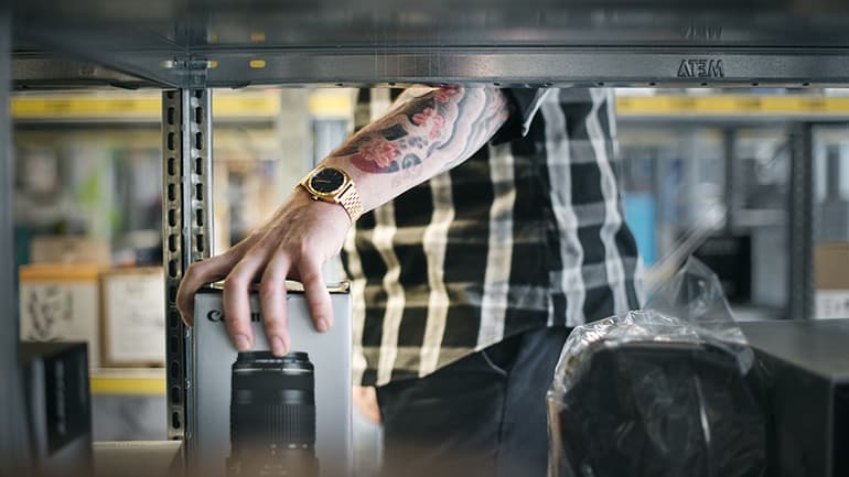 Braccio tatuato dietro lo scaffale