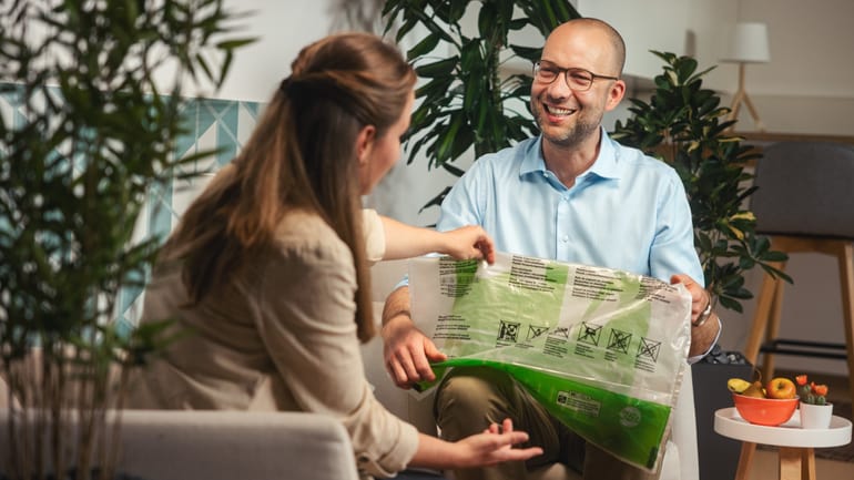 Zwei Personen betrachten Recycling-Beutel