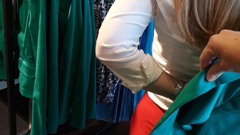 Frau zieht Blazer an