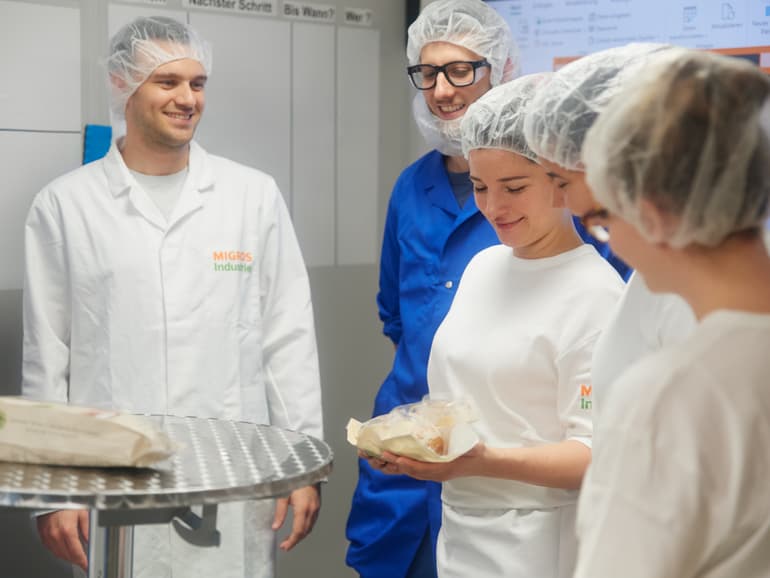 Team schaut sich fertig hergestelltes Brot an