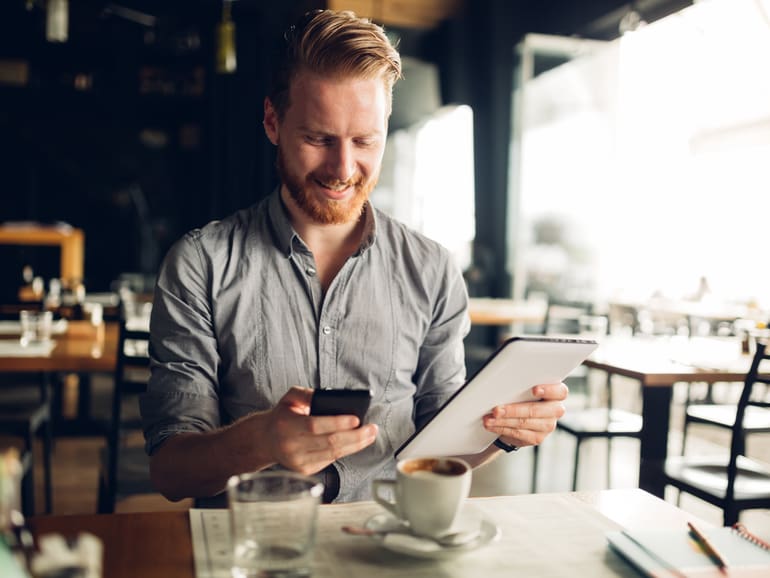 Uomo con cellulare e tablet in mano