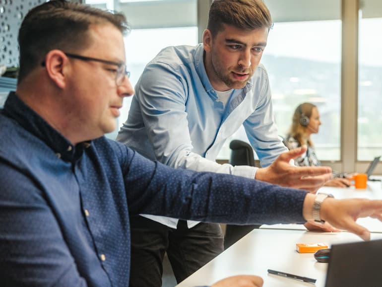 Zwei Personen besprechen ein Projekt am Bildschirm
