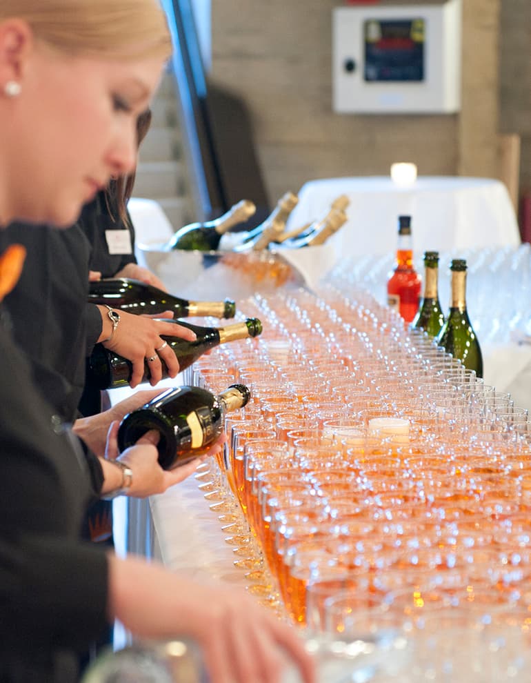 Collaboratori che versano champagne