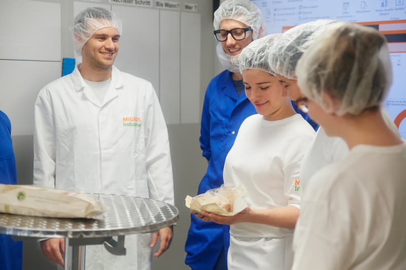 Team schaut sich fertig hergestelltes Brot an