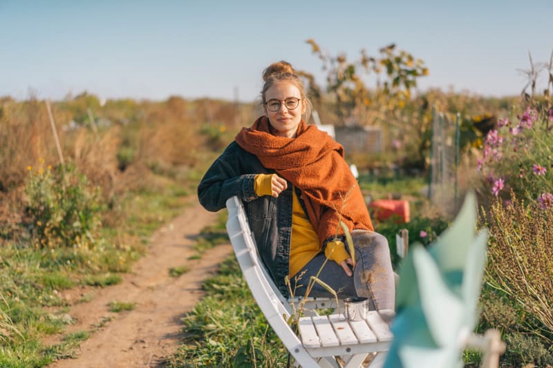 Frau mit Brille auf einer Bank in der Natur