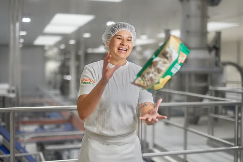 Produktionsmitarbeitende wirft Chipspackung in Luft