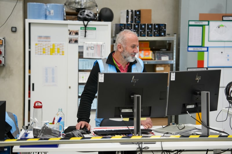 Mann steht an seinem Bürotisch