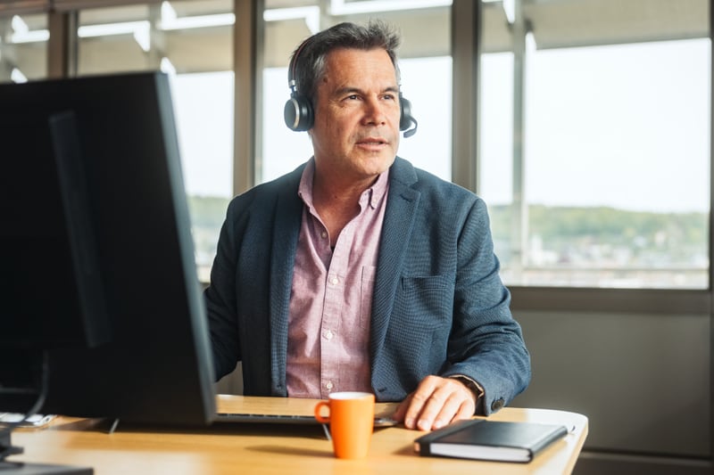 Mann mit Headset an Arbeitsplatz