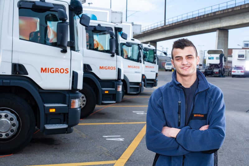 Un apprendista autista di veicoli pesanti di fronte al parcheggio dei camion