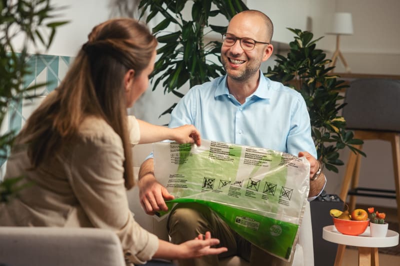 Zwei Personen betrachten Recycling-Beutel