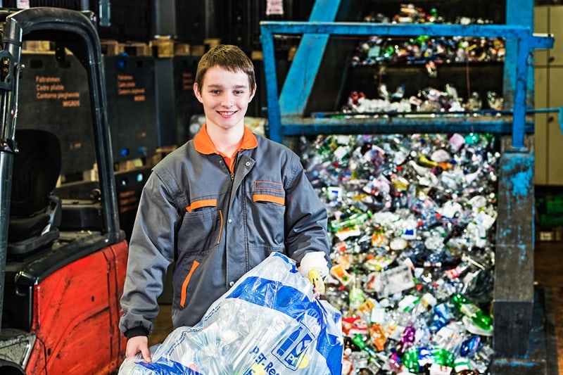 Un apprendista riciclatore con un sacchetto di plastica per le bottiglie in PET